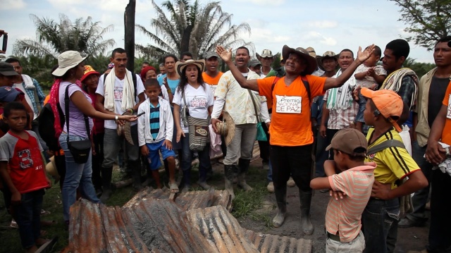 Orlando Ospino, miembro de la comunidad de Las Pavas canta delante a los restos de un rancho quemado por órdenes de la empresa palmera Aportes San Isidro